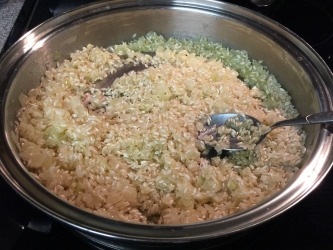 <p>Add rice (Arborio), stir the mixture until rice is completely  coated with onions & garlic, about 2 minutes.</p>